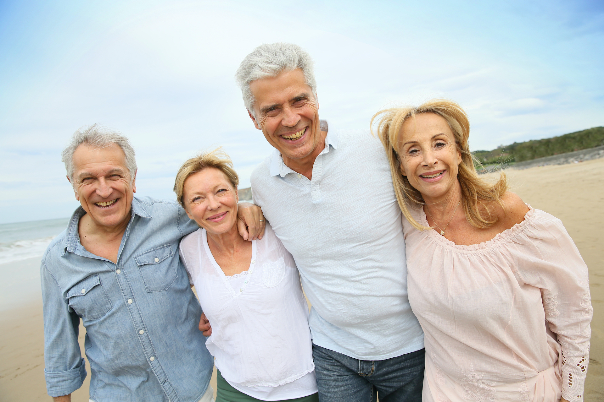 Senior people walking on the beach.